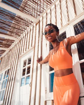 Oceans-Apart-Kampagne: Model in Orange auf einer Holzveranda