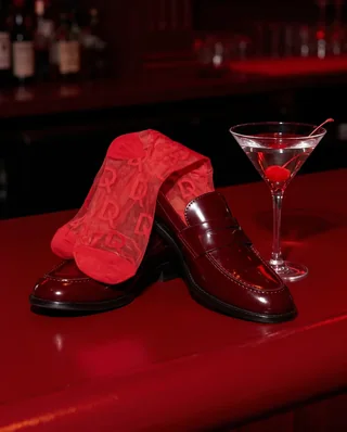 D-SoQs: Socken und Loafer neben einem Martiniglas