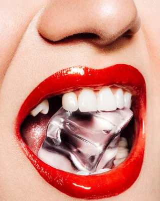 Beauty-Nahaufnahme: rote Lippen mit Eiswürfel