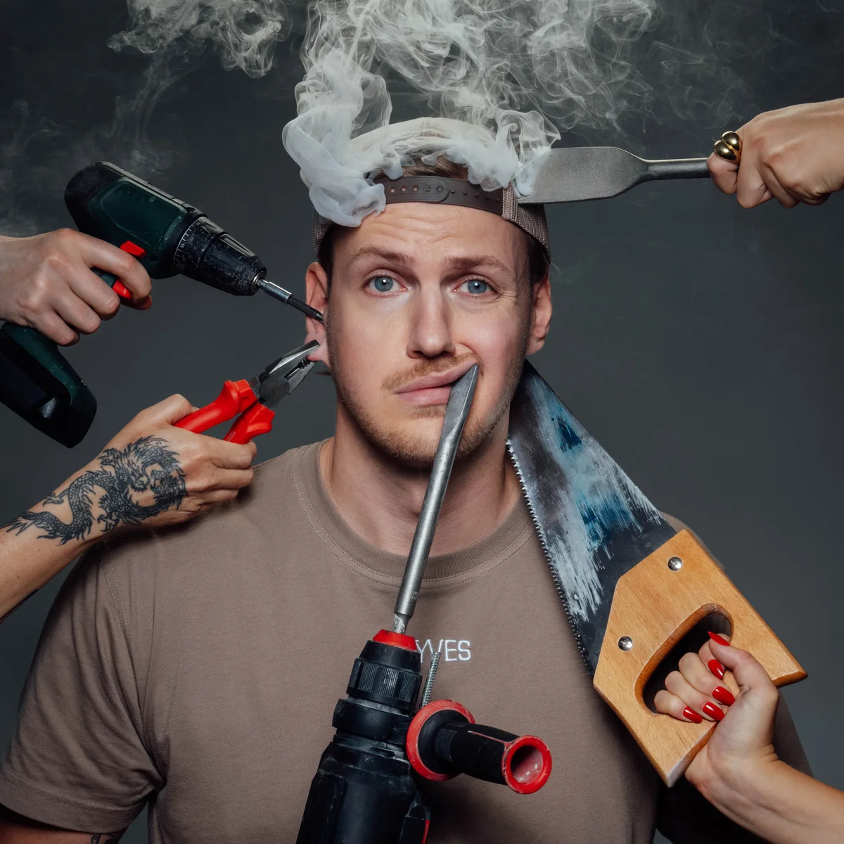 Portrait of Kai Baum surrounded by hands holding power tools, smoke rising from his head