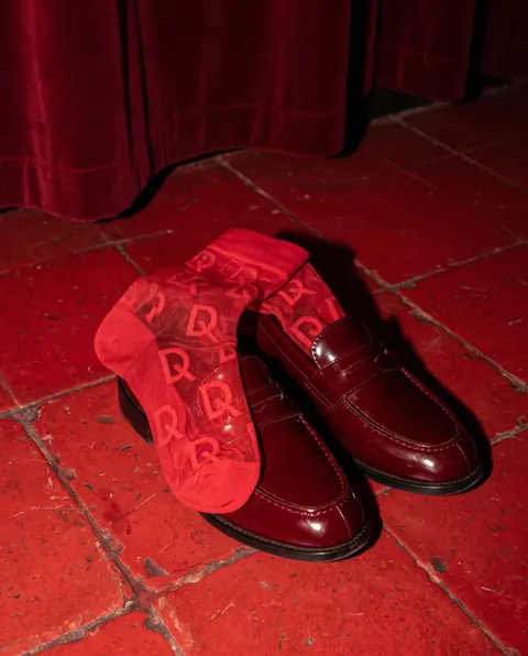Rote D-SoQs-Socken mit Loafern auf roten Fliesen
