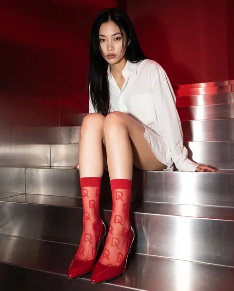 Miko im weißen Hemd mit roten D-SoQs-Socken